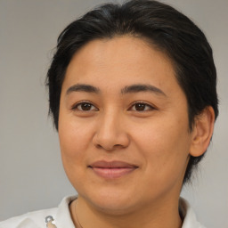 Joyful latino young-adult female with medium  brown hair and brown eyes