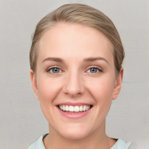 Joyful white young-adult female with medium  brown hair and blue eyes