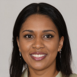 Joyful black young-adult female with long  brown hair and brown eyes