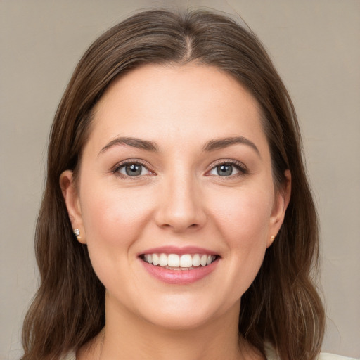 Joyful white young-adult female with long  brown hair and brown eyes