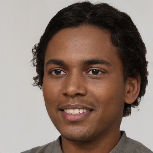 Joyful black young-adult male with short  black hair and brown eyes