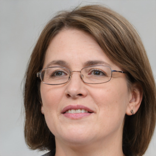 Joyful white adult female with medium  brown hair and blue eyes