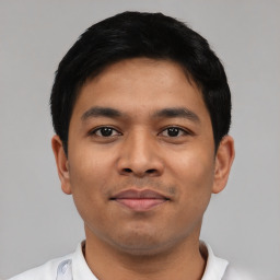 Joyful latino young-adult male with short  black hair and brown eyes