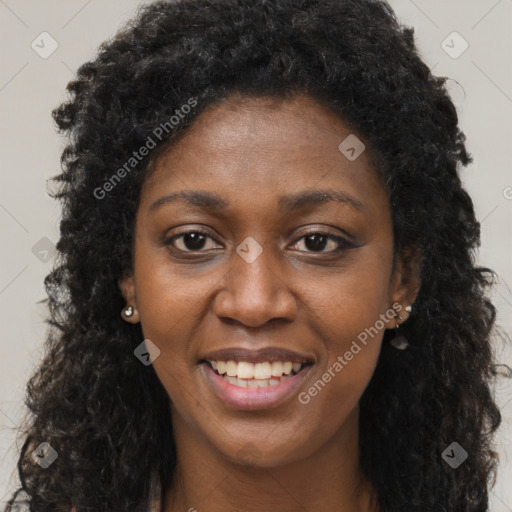 Joyful black young-adult female with long  brown hair and brown eyes