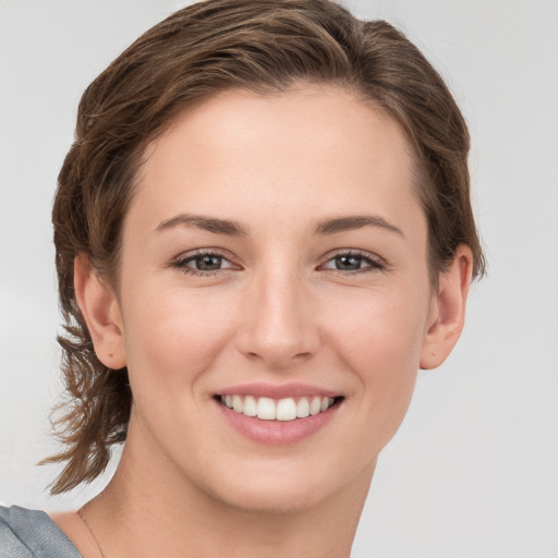 Joyful white young-adult female with medium  brown hair and grey eyes