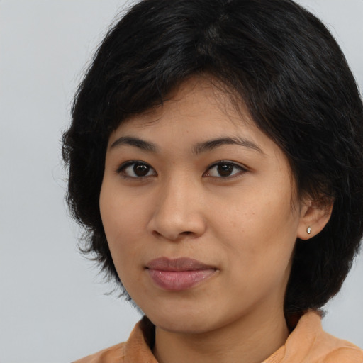 Joyful latino young-adult female with medium  black hair and brown eyes