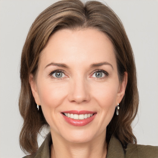 Joyful white adult female with medium  brown hair and grey eyes