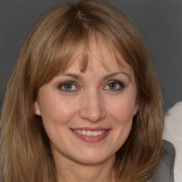 Joyful white adult female with medium  brown hair and brown eyes