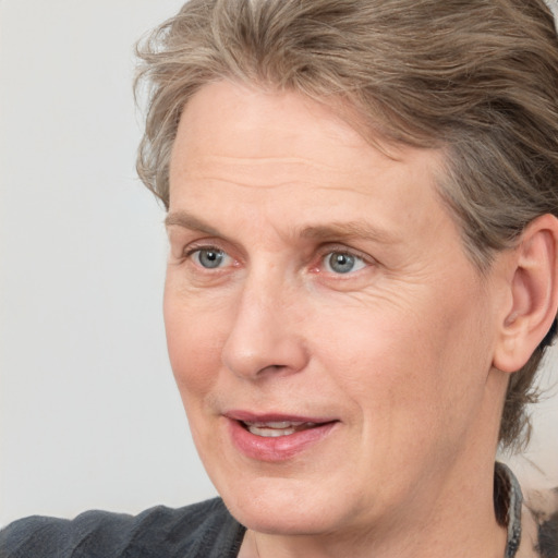 Joyful white adult female with medium  brown hair and grey eyes