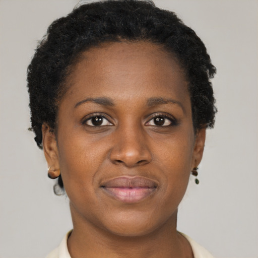 Joyful black young-adult female with short  brown hair and brown eyes