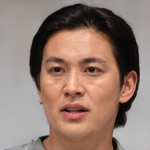 Joyful asian adult male with short  brown hair and brown eyes