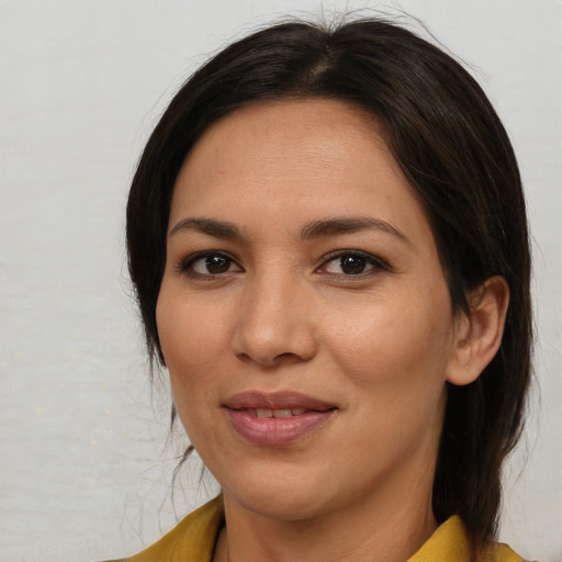 Joyful latino young-adult female with medium  brown hair and brown eyes