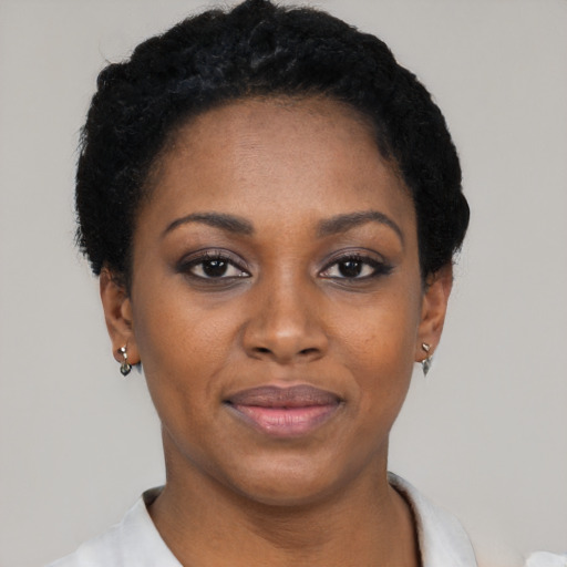 Joyful black young-adult female with short  black hair and brown eyes
