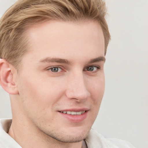 Joyful white young-adult male with short  brown hair and blue eyes