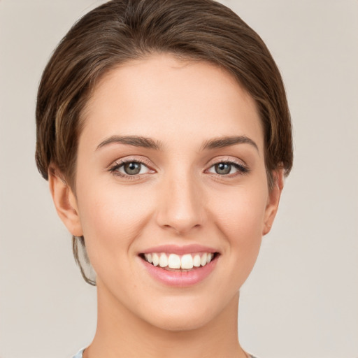 Joyful white young-adult female with short  brown hair and green eyes