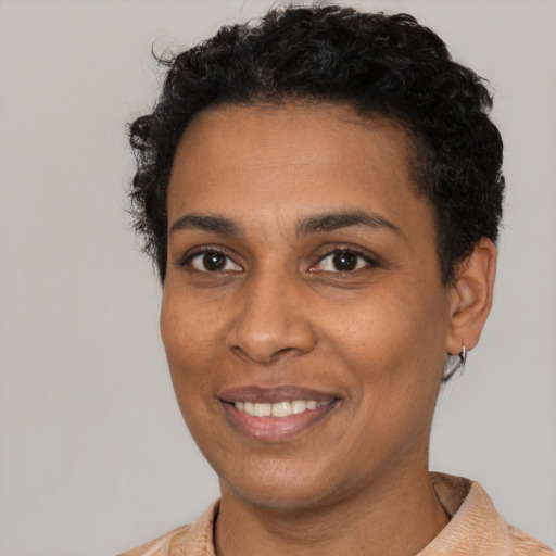Joyful black young-adult female with short  black hair and brown eyes
