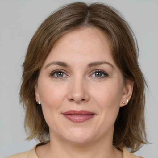 Joyful white adult female with medium  brown hair and grey eyes