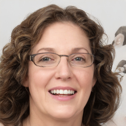 Joyful white adult female with medium  brown hair and blue eyes