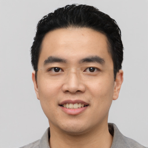 Joyful asian young-adult male with short  black hair and brown eyes
