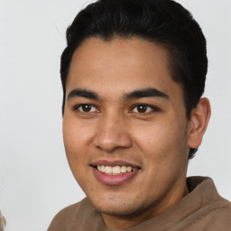 Joyful latino young-adult male with short  brown hair and brown eyes