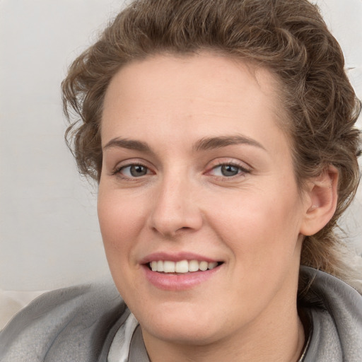 Joyful white young-adult female with short  brown hair and blue eyes