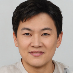 Joyful asian young-adult male with short  brown hair and brown eyes