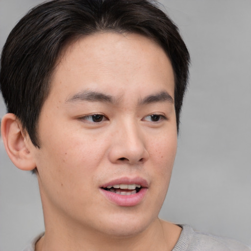 Joyful asian young-adult male with short  brown hair and brown eyes