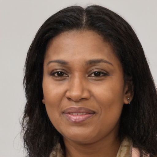 Joyful black adult female with long  brown hair and brown eyes
