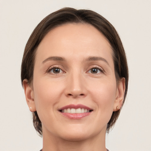 Joyful white young-adult female with medium  brown hair and grey eyes