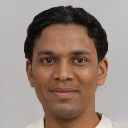 Joyful black young-adult male with short  black hair and brown eyes