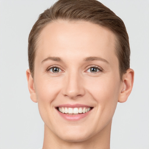 Joyful white young-adult female with short  brown hair and grey eyes