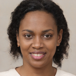 Joyful black young-adult female with long  brown hair and brown eyes