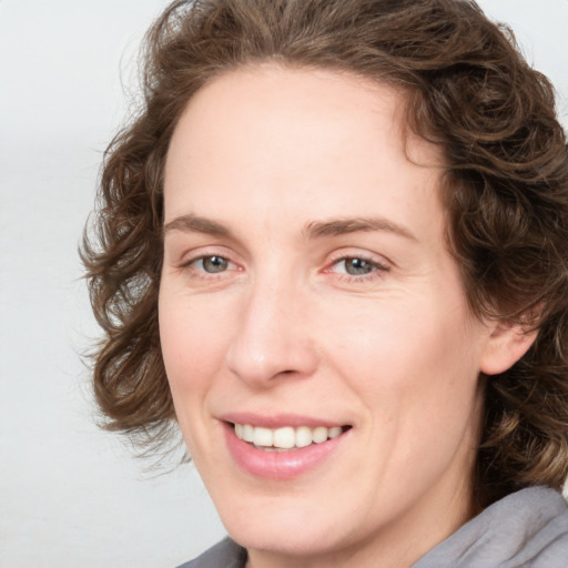 Joyful white young-adult female with medium  brown hair and green eyes