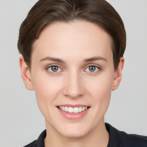 Joyful white young-adult female with short  brown hair and grey eyes