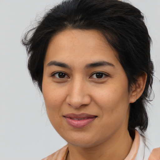 Joyful latino young-adult female with medium  brown hair and brown eyes