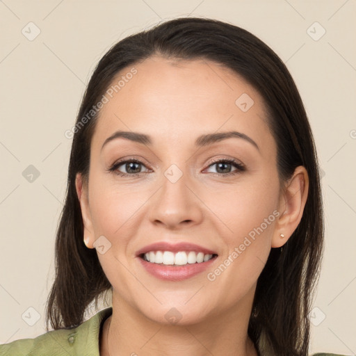 Joyful white young-adult female with long  brown hair and brown eyes