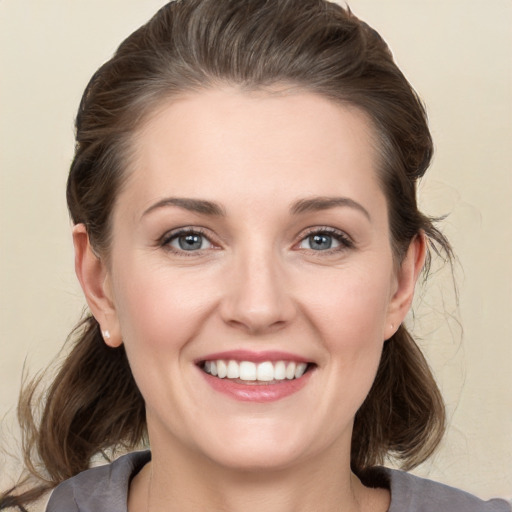 Joyful white young-adult female with medium  brown hair and grey eyes