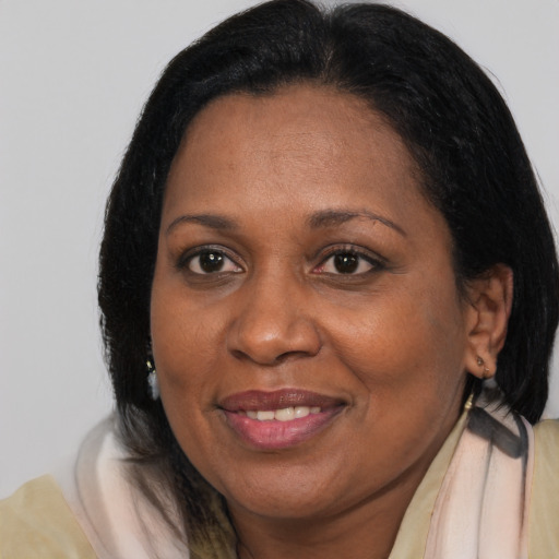 Joyful black adult female with medium  brown hair and brown eyes