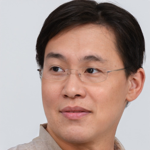 Joyful asian adult male with short  brown hair and brown eyes