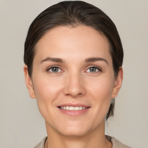 Joyful white young-adult female with short  brown hair and grey eyes