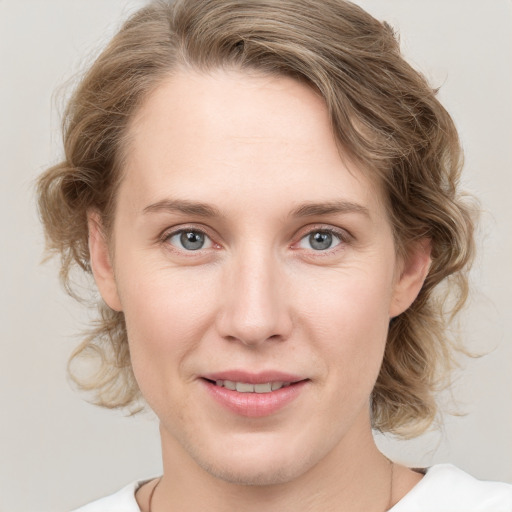 Joyful white young-adult female with medium  brown hair and blue eyes