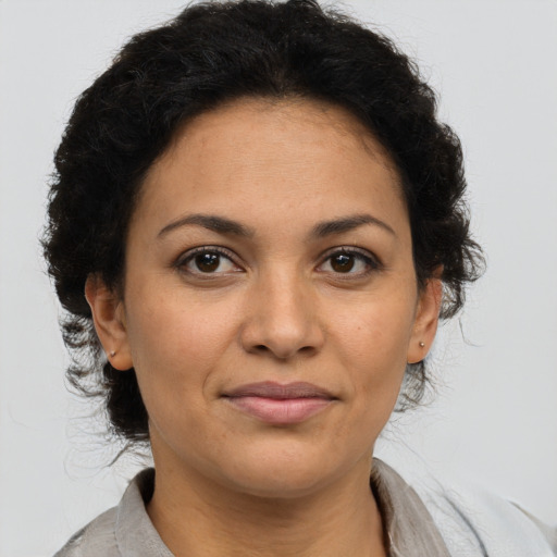 Joyful latino adult female with medium  brown hair and brown eyes