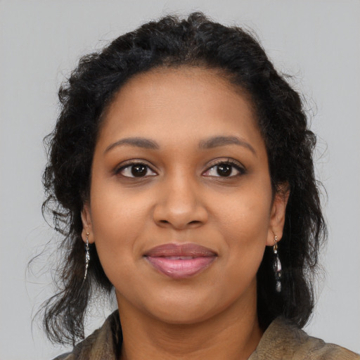 Joyful black young-adult female with long  brown hair and brown eyes