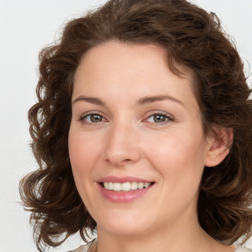 Joyful white young-adult female with medium  brown hair and green eyes