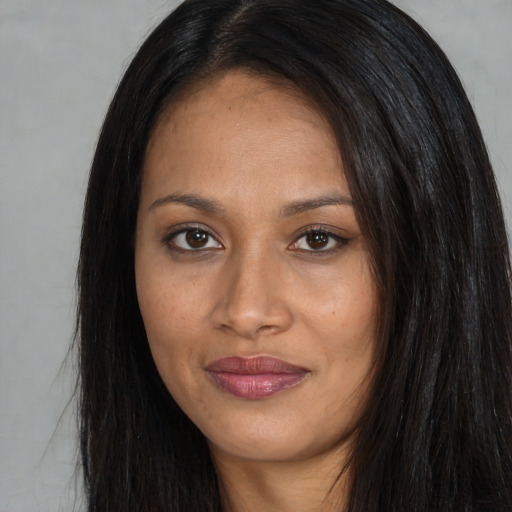 Joyful black young-adult female with long  black hair and brown eyes