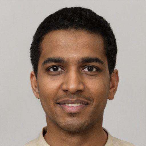 Joyful black young-adult male with short  black hair and brown eyes