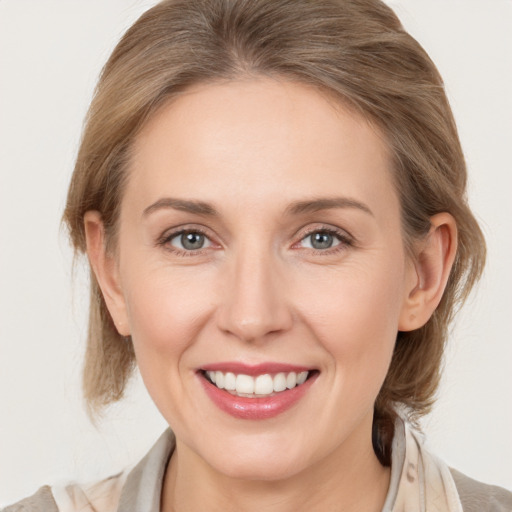 Joyful white adult female with medium  brown hair and grey eyes