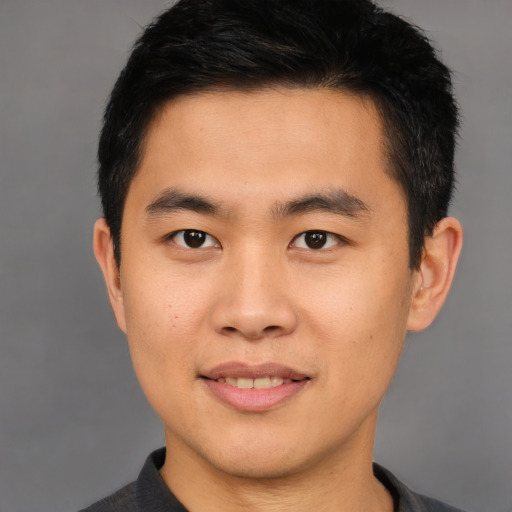 Joyful asian young-adult male with short  brown hair and brown eyes