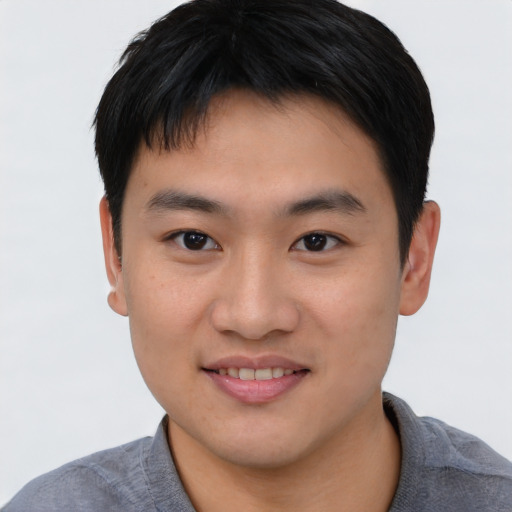 Joyful asian young-adult male with short  brown hair and brown eyes