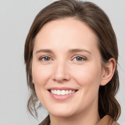 Joyful white young-adult female with medium  brown hair and grey eyes